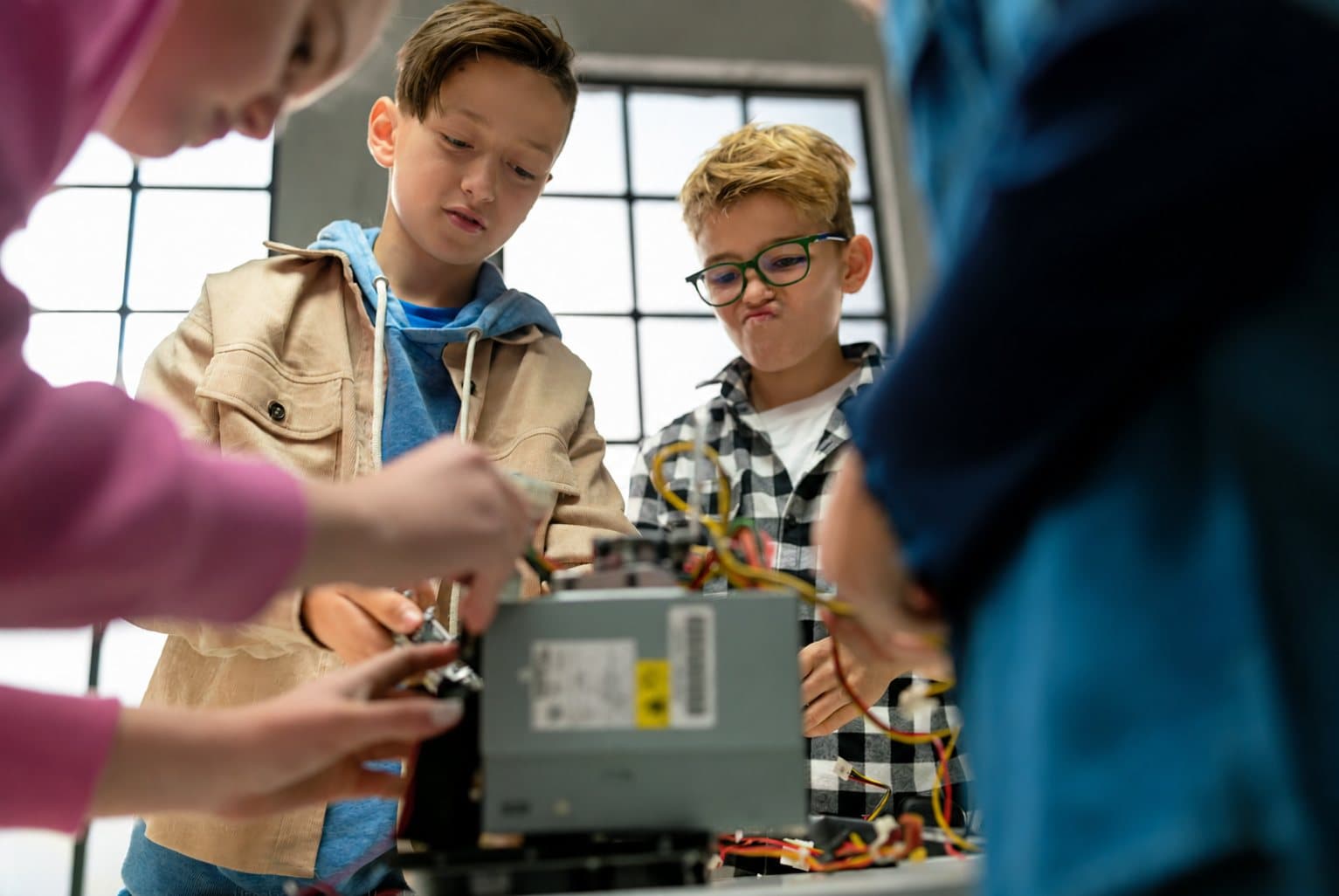 Een groep leerlingen onderzoekt samen de binnenkant van een computer.